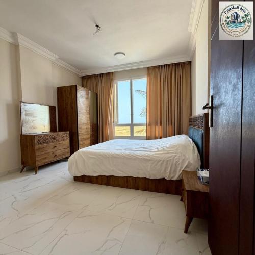 a bedroom with a large bed and a window at المنصور 3 in Salalah