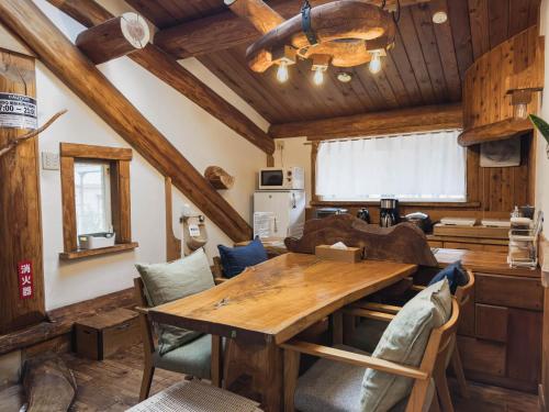 a kitchen and dining room with a wooden table and chairs at Kawazu Log House in Kawazu