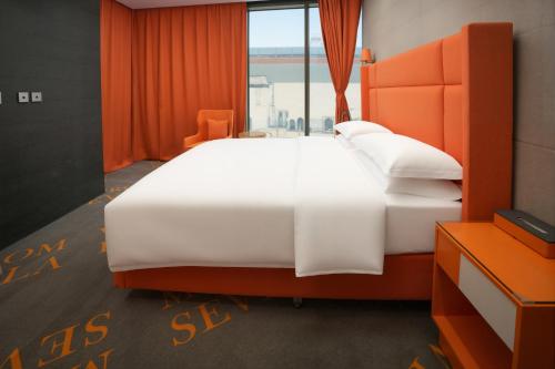 un grande letto bianco in una stanza con una finestra di HUAZHU LUYI Service Apartment 华住庐艺 a Riyad