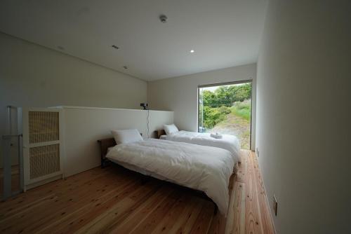 a bedroom with a large bed and a window at 紀の川みんと景 in Kinokawa