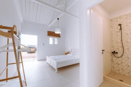 a white bedroom with a bed and a ladder at Burano Camping Beach-Bar in Néa Thésis