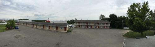 a large parking lot in front of a building at Hotel Motel Hospitalité in Lévis
