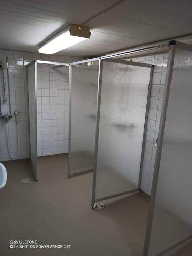 a bathroom with three stalls with doors in it at Tattara School Room 2 in Nakkila
