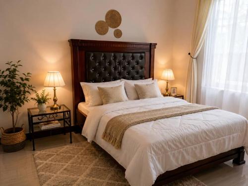 a bedroom with a large bed and two tables with lamps at Kivulini Homes in Arusha