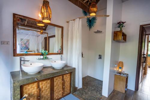 a bathroom with two sinks and a mirror at Buko Beach Resort in El Nido