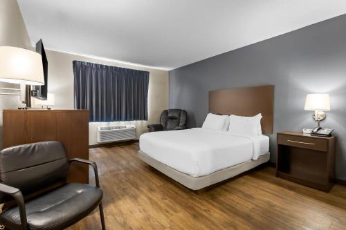 a hotel room with a bed and a chair at Park Inn by Radisson Ortonville in Ortonville