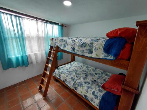 a bedroom with two bunk beds and a window at Finca Itaca in San Esteban Tizatlán