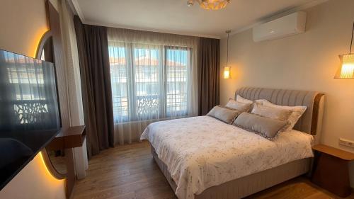 a bedroom with a bed and a large window at Limani Vasiliko in Tsarevo