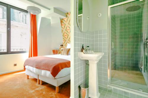 a bathroom with a bed and a shower and a sink at Le Charmant Hôtel in Saint-Ouen