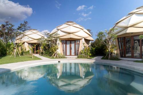 a house with a swimming pool in front of it at Nuanu Suites & Accommodations in Tabanan