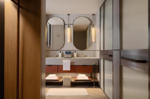 a bathroom with a sink and two mirrors at Canopy By Hilton Bangkok Sukhumvit in Bangkok