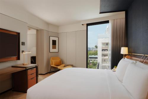a hotel room with a large bed and a television at Canopy By Hilton Bangkok Sukhumvit in Bangkok