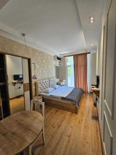 a bedroom with a bed and a table in it at Happy Stay Hotel in Kutaisi