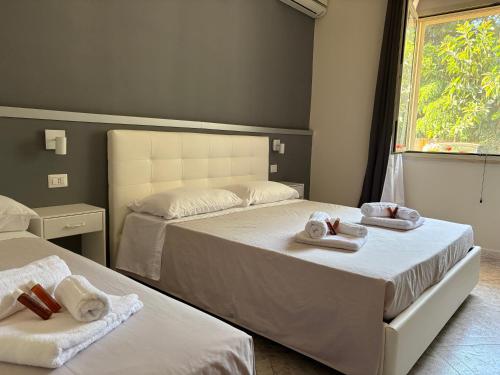 two beds in a room with towels on them at Chill House Reggio Calabria in Reggio di Calabria