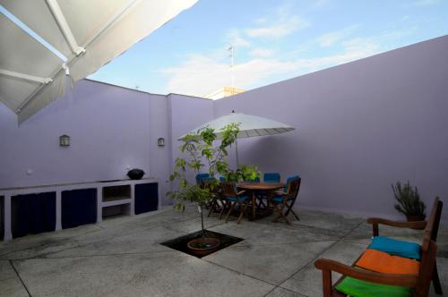 a dining room with a table and an umbrella at La Casa del Limonero in El Puerto de Santa María