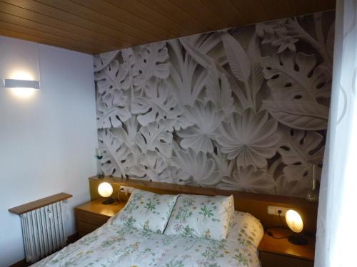 1 dormitorio con 1 cama y una pared con flores en Apartment La Molina, en La Molina