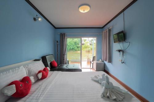 a bedroom with a bed with stuffed animals on it at แพ ณ จันทร์ in Sathani Nam Tok