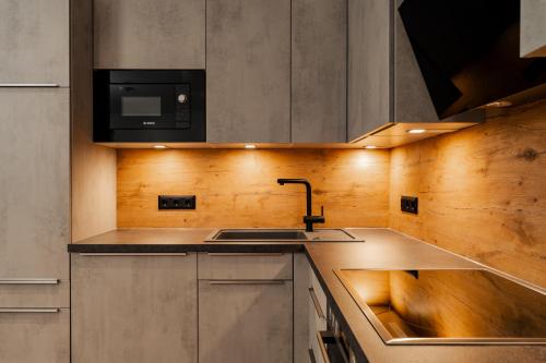 a kitchen with a sink and a microwave at Peak9 Apartment in Greifenburg
