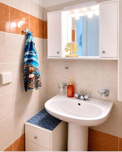 a bathroom with a sink and a mirror at Whisper wave in Haraki