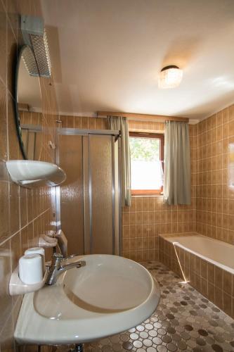 a bathroom with a sink and a tub at Gasthaus Zum Stampf in Strass im Attergau