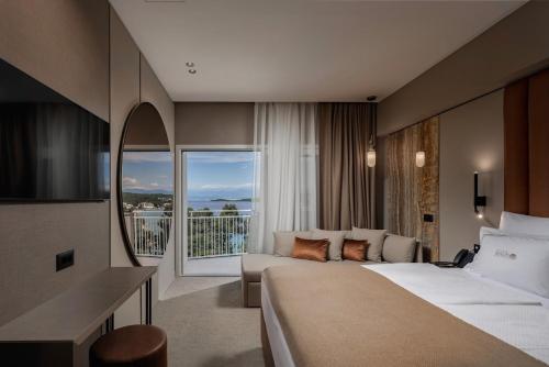 a hotel room with a bed and a large window at Hotel Malin in Malinska