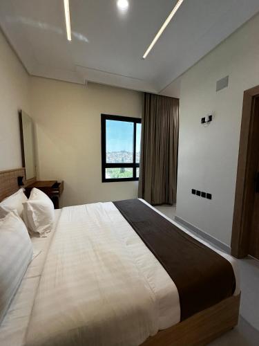 a bedroom with a large bed with a window at بيوت عطلات البيت الريفي للضيافه السياحي in Al Namas