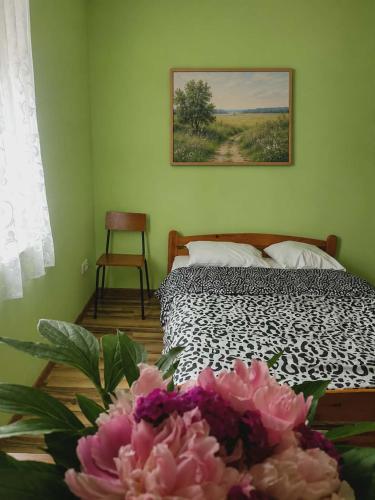 a bedroom with a bed and a bouquet of flowers at Hostel Promyk in Iwonicz-Zdrój