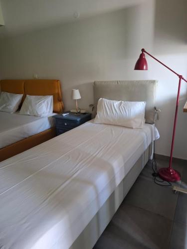 a bedroom with two beds and a red lamp at Nicole's Cave Studio in Pylos