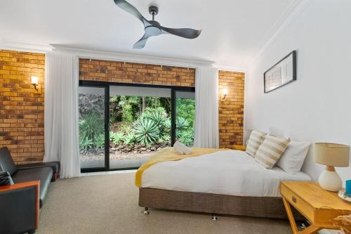 a bedroom with a bed and a large window at The Hidden Gem in Tamborine Mountain in Tamborine