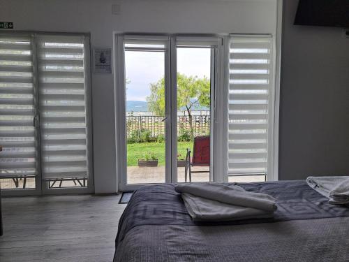 a bedroom with white shutters and a bed with a view at Apartmani Đorđević 2 in Golubac