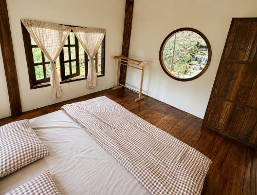 a bedroom with a bed and a large window at Teepo Ke Hillside Jungle Lodge in Ban Mae Sapok Nua