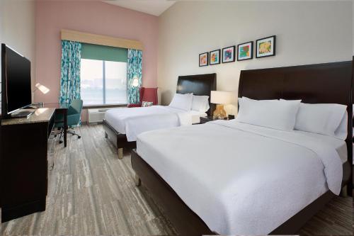 a hotel room with two beds and a desk at Hilton Garden Inn Akron in Akron