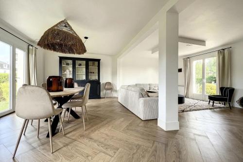 a living room with a table and a couch at Spacious house 300m from the beach in Hermanville-sur-Mer