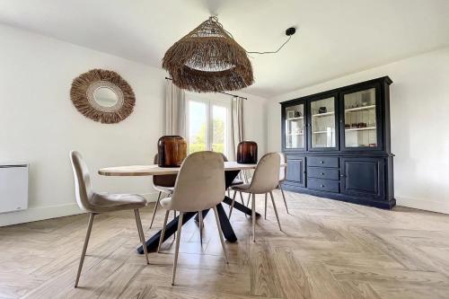 a dining room with a table and chairs and a mirror at Spacious house 300m from the beach in Hermanville-sur-Mer