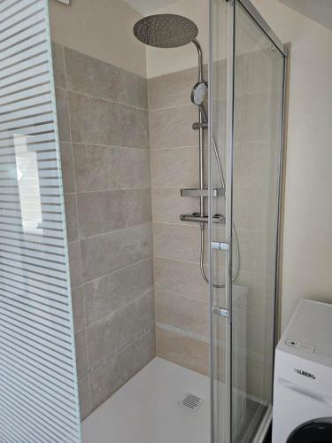 a bathroom with a shower with a glass door at Cap à l'ouest in Saint-Benoît-des-Ondes