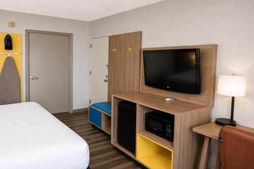 a hotel room with a bed and a flat screen tv at Days Inn by Wyndham Donalsonville in Donalsonville
