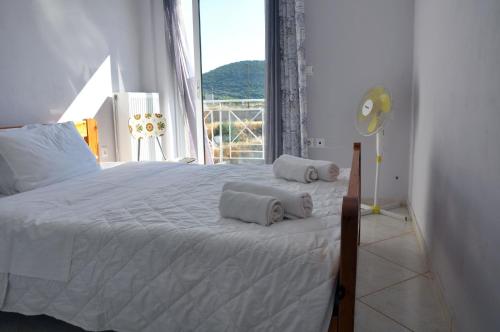 a bedroom with a white bed with towels on it at Valtaki Holiday Home in Selinitsa