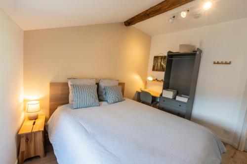 a bedroom with a large bed and a flat screen tv at Appartement central - L'est in Tarare