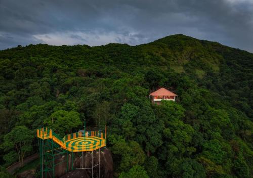 a house on top of a hill with a playground at Celestial Heights Coorg by VOYE HOMES with Sunset views-Near to Nagarhole Tiger Reserve in Srimangala