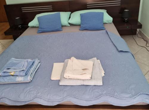 a bed with blue sheets and towels on it at Apartments Blink in Orebić