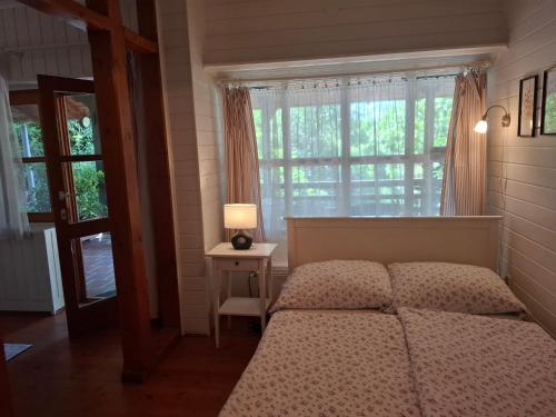 a bedroom with a bed and a window with a lamp at Agyagos Vendégház in Eger