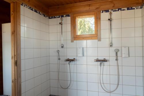 a bathroom with two shower heads and a window at Oravi Villa 1 Teeri in Savonlinna