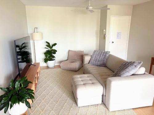 a living room with a couch and a chair at Melrose Place at Flynn's Beach in Port Macquarie