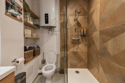 a bathroom with a toilet and a shower at Appartement central - L'est in Tarare