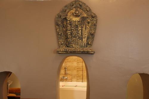 an archway with an ornate artifact on the wall at Thimura Resort in Bharatpur