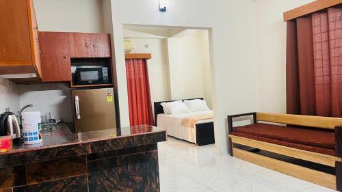 a hotel room with a bed and a kitchen at Best Eastern Suite in Dhaka