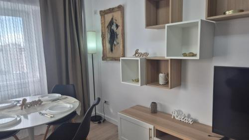 a bathroom with a table and a sink and a tv at Unirii Residence in Bacău