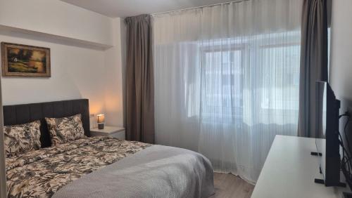 a bedroom with a bed and a large window at Unirii Residence in Bacău