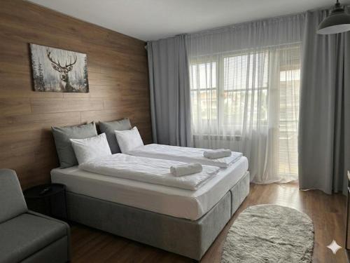 a bedroom with a bed and a chair and a window at комплекс Иван и Петър in Belitsa