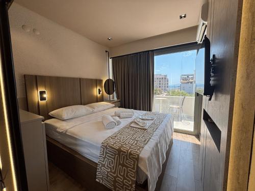 una camera d'albergo con un letto e una grande finestra di Aterna Hotel a Dikili